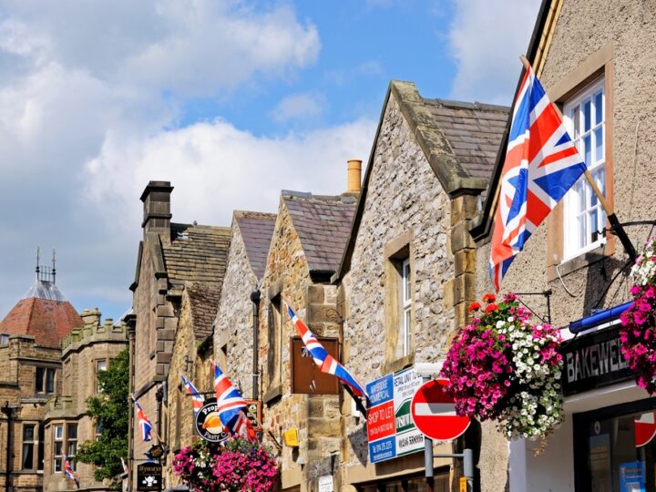 Row of British flags on shop walls in the town centre, Bakewell