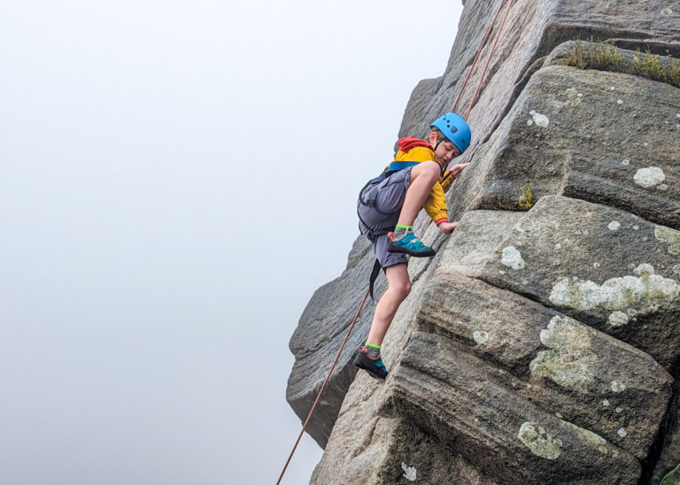 a boy rock climbing in the Peak District